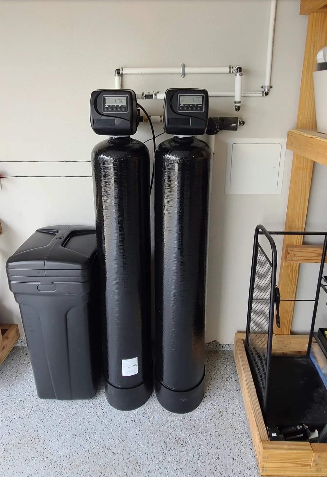 Dual black water softener tanks with digital controls and PVC piping installed in utility space Dual black water softener tanks with digital controls and PVC piping installed in utility space
