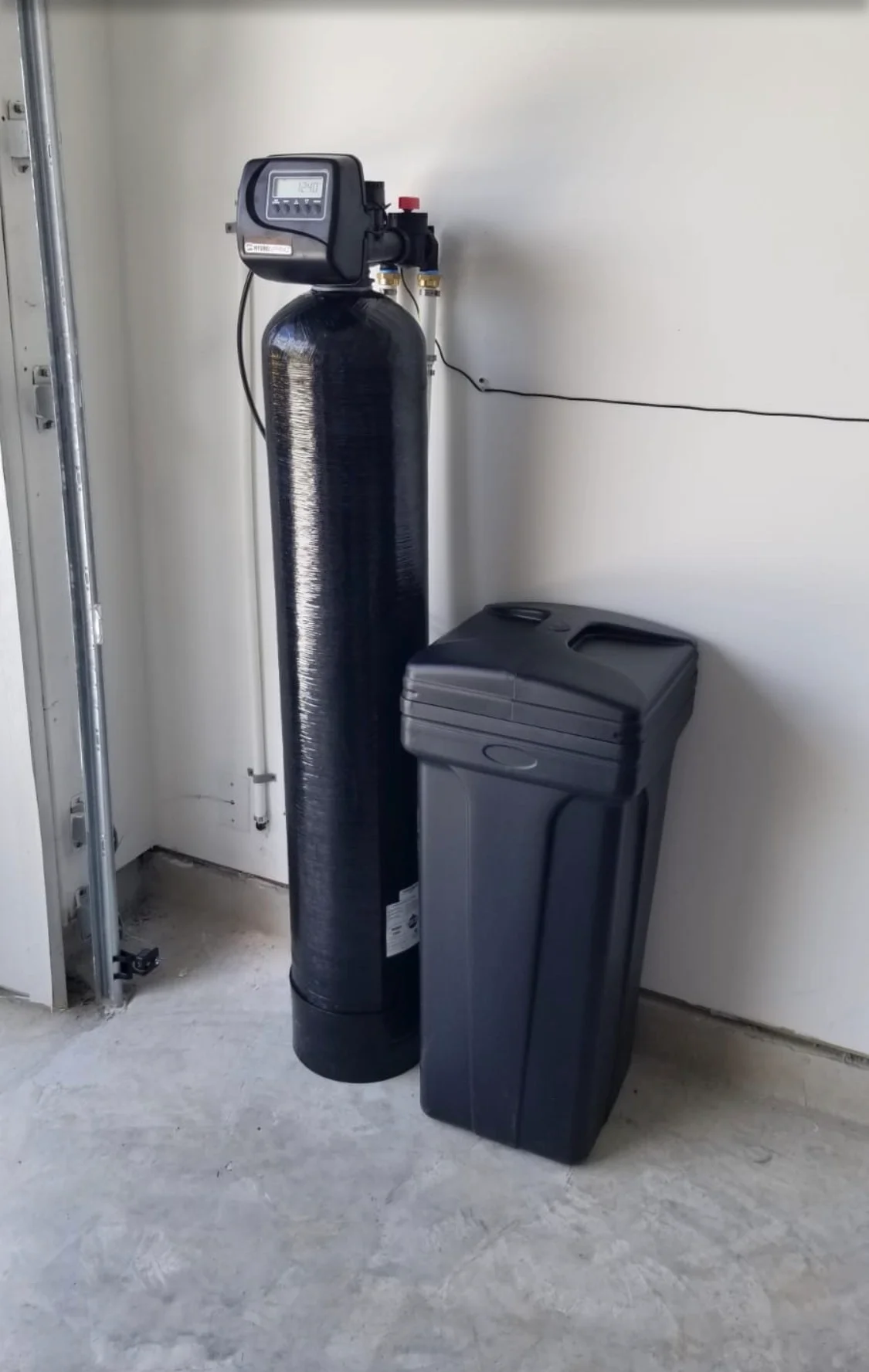 Black water softener and brine tank system installed in basement utility room Black water softener and brine tank system installed in basement utility room